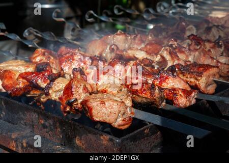 Köstliche und saftige Schweinefleisch Kebab auf Spieße Grillen auf offenem Grill, Konzept der Outdoor-bbq-Party am frühen Frühlingstag. Nahaufnahme Stockfoto