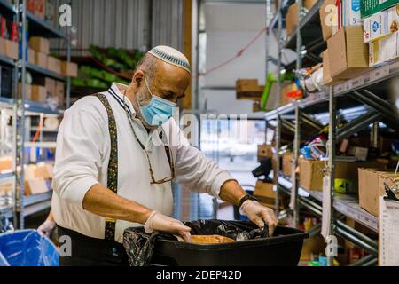 Toronto, Kanada. November 2020. Ein Freiwilliger, der eine Maske trägt, bereitet Mahlzeiten in der Chasdei Kaduri Jewish Food Bank zu.Es ist die einzige jüdische Organisation, die vollständig von Freiwilligen betrieben wird und sich der wöchentlichen Lieferung von nicht verderblichen Lebensmitteln, frischen Backwaren und Produkten an Hunderte bedürftiger jüdischer Familien im Großraum Toronto widmet. Seit der Pandemie covid-19 im März 2020 ist die Nachfrage nach ihren Diensten stark gestiegen. Quelle: Shawn Goldberg/SOPA Images/ZUMA Wire/Alamy Live News Stockfoto