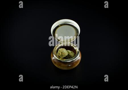 Unkraut. Cannabisknospen auf EINEM Keramikglas isoliert über schwarzem Hintergrund Stockfoto