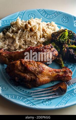 Authentische pikante jamaikanische Jerke Chicken Legs serviert mit Kokosreis Und Taubenerbsen Stockfoto