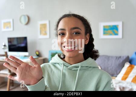 Glücklich gen z teen Mädchen winken Hand im Schlafzimmer mit der Kamera sprechen. Stockfoto