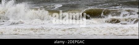 An einem stürmischen Tag im Atlantik rollt eine kleine Welle am Ufer. Stockfoto