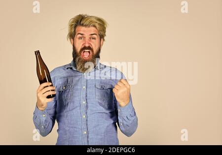 Sport Liebhaber aufmuntern. Reifer Mann hält Glasflasche Bier. Betrunken Hipster männlichen Handwerk Flaschenbier. Glücklicher Mann halten volle Glasflasche in der Hand. Männlich Stockfoto