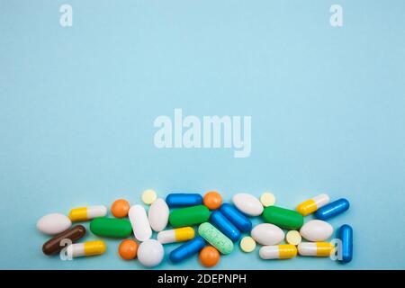 Mehrfarbige Tabletten und Kapseln, pharmazeutische Medikamente Pillen auf blauem Hintergrund, Analgetikum gegen Krankheiten Stockfoto