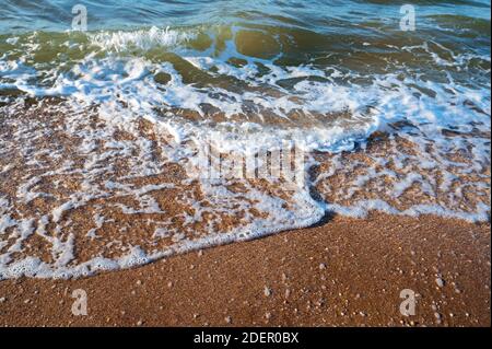 Nahaufnahme der Flutwassersurfen auf dem Sandstrand. Selektiver Fokus Stockfoto