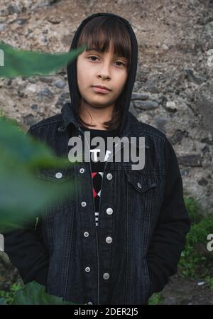 Mädchen mit einer schwarzen Jacke und Hände in Taschen suchen Bei der Kamera trotzig Stockfoto