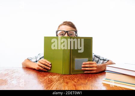 Teen guy schlief mit Büchern sitzend ein, Student schlafend am Schreibtisch im Studio Stockfoto