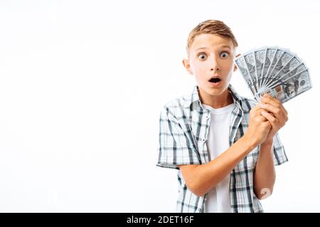 Junger Mann hält eine Menge hundert Dollar-Scheine, Teenager-Kerl schockiert durch eine Menge Geld, in Studio Stockfoto