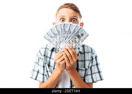 Junger Mann in Brille hält viele hundert Dollar Scheine vor dem Gesicht, Gesicht aus der Nähe, im Studio Stockfoto