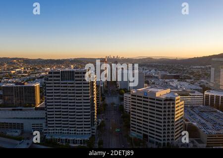 Luftaufnahme bei Sonnenuntergang mit Blick nach Süden entlang des Brand Boulevard Die Skyline von Glendale mit der Skyline von Downtown Los Angeles in der Ferne Stockfoto