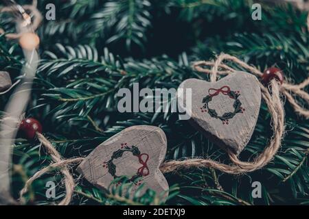 Draufsicht weihnachtskomposition aus wilden christbaumzweigen und Schnur aus Holzherzen mit Girlande-Print, Schnur mit Lichterketten gemischt, bläulich Stockfoto