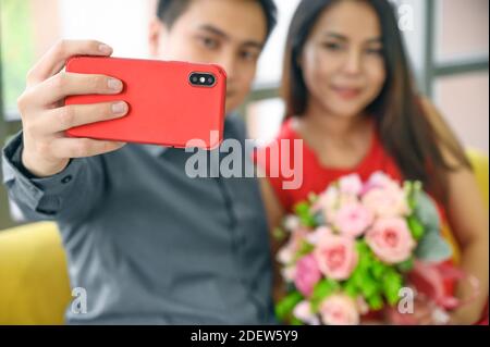 Mann Hand hält Telefon für Selfie. Romantisches Paar in der Liebe Blick auf Smartphone zu Hause. Technologie für Beziehungskonzept. Stockfoto