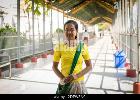 Porträt einer lächelnden Frau mit Blattmarkierungen auf ihrem Gesicht von thanaka, Mandalay, Myanmar Stockfoto