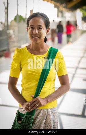 Porträt einer lächelnden Frau mit Blattmarkierungen auf ihrem Gesicht von thanaka, Mandalay, Myanmar Stockfoto