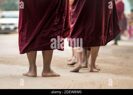 Detailaufnahme der Füße von Mönchen, die in der Schlange warten, während sie Almosen empfangen, Nyaung U, Myanmar Stockfoto