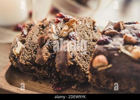 Nahaufnahme von hausgemachten, zuckerarmen Trockenfrüchten in Scheiben geschnitten Kuchen mit gesunden Mischnüssen auf Holzplatte Stockfoto