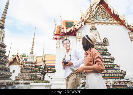 Junge asiatische Fotograf Tourist mit seiner Freundin Besuch Thai Tempel, Wat Phra Chetuphon (Wat Pho), in Bangkok Thailand in den Sommerferien Stockfoto