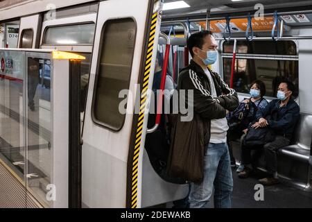 Hongkong, China. Dezember 2020. Passagiere mit Gesichtsmasken fahren in einer MTR-U-Bahn. Die Regierung Hongkongs verschärft die Regeln für die soziale Distanzierung und schließt die Schulen, da das Land einer neuen Welle von Covid-19-Fällen ausgesetzt ist. Kredit: SOPA Images Limited/Alamy Live Nachrichten Stockfoto