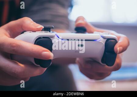 Person, die den PlayStation 5 DualSense Gaming-Controller hält Stockfoto