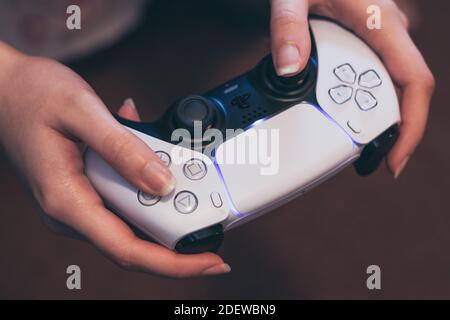 Person, die den PlayStation 5 DualSense Gaming-Controller hält Stockfoto