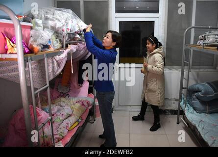 (201202) -- WUHU, 2. Dezember 2020 (Xinhua) -- Xi Weijing, Leiter der Wuhu Schule für Blinde, hilft einem Schüler, seine Sachen aufzuräumen, während er Wohnheime in der Schule in der Stadt Wuhu, Ostchinas Provinz Anhui, inspiziert, 25. November 2020. XI Weijings Eltern sind beide sehbehindert. Ihr Vater Xi Manqiao hat 1979 eine Privatschule für Blinde eingerichtet und seine ganze Energie der Arbeit der Schule gewidmet. Nachdem ihr Vater 1994 an Krankheit starb, übernahm Xi Weijing, damals 20 Jahre alt, die Last und wurde zum zweiten Direktor der Wuhu Blindenschule. Mit Unterstützung der lokalen Regierung, die W Stockfoto