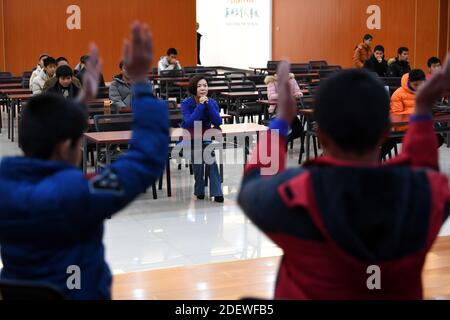 (201202) -- WUHU, 2. Dezember 2020 (Xinhua) -- Xi Weijing, Leiter der Wuhu Schule für Blinde, beobachtet die Proben der Schüler für den bevorstehenden Internationalen Tag der Menschen mit Behinderungen in der Schule in der Stadt Wuhu, ostchinesische Provinz Anhui, 25. November 2020. XI Weijings Eltern sind beide sehbehindert. Ihr Vater Xi Manqiao hat 1979 eine Privatschule für Blinde eingerichtet und seine ganze Energie der Arbeit der Schule gewidmet. Nachdem ihr Vater 1994 an Krankheit starb, übernahm Xi Weijing, damals 20 Jahre alt, die Last und wurde zum zweiten Direktor der Wuhu Blindenschule. Mit dem support Stockfoto