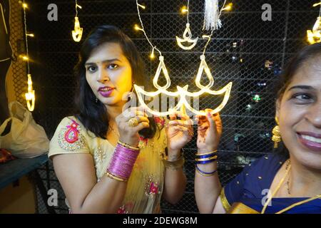 Mumbai / Indien 14 November 2020 EIN zwei lächelnder Inder Verheiratete Frauen in traditionellem Sari-Kleid mit LED-Diya-String Lichter anlässlich der Diwali Stockfoto
