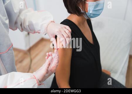 Arzt, der einer schwangeren Frau einen Impfstoff gegen Covid 19 oder Grippe oder Keuchhusten verabreicht. Stockfoto