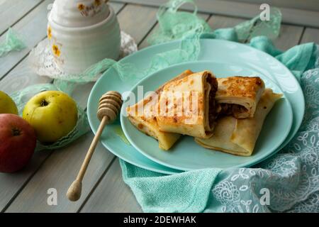 Apfelcinnamon Crepes. Pfannkuchen mit karamellisierten Äpfeln und Zimt. Blaugrün Hintergrund Stockfoto