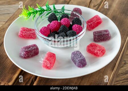 Kauen Marmelade Gelee Bonbons mit Beerengeschmack auf Holztisch. Stockfoto