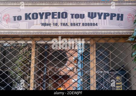 Athen, Griechenland. 12. November 2020. Barbershop PSIRI in Monastiraki, COVID19 Coronavirus-Sperre. Traditioneller alter Friseursalon mit Metallgittern geschlossen Stockfoto