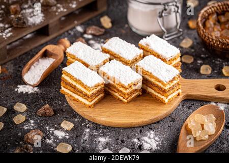 Stillleben von hausgemachten kleinen geschichteten Kuchen auf Holzschnitt Platine Stockfoto