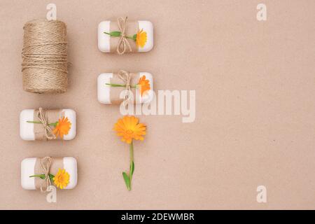 Handgemachte natürliche Toilettenseife mit Bastelpapier verziert, gebunden mit Geißel, Ringelblume Blumen und Skein aus Garn. Bio-Kosmetik, keine Abfälle, e Stockfoto