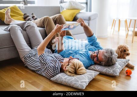 Schönes Lächeln reifes Paar Spaß haben, während mit Tablet an Zu Hause Stockfoto