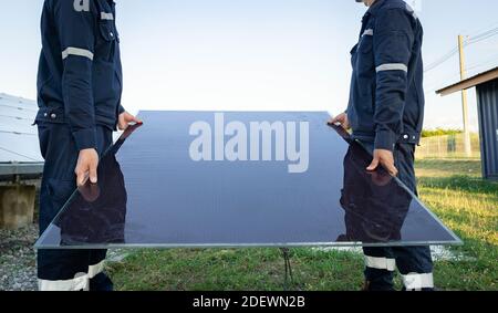 Der Techniker hebt die Solarzelle, um die beschädigte zu ersetzen, Alternative Energie, um die Energie der Welt zu sparen, Photovoltaikmodul Idee für sauber. Stockfoto