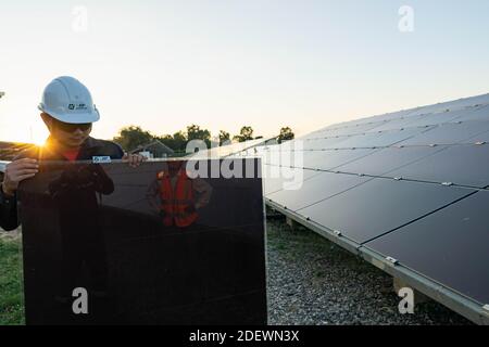 Techniker hebt die Solarzelle, um die beschädigte zu ersetzen, Alternative Energie, um die Energie der Welt zu sparen. Stockfoto