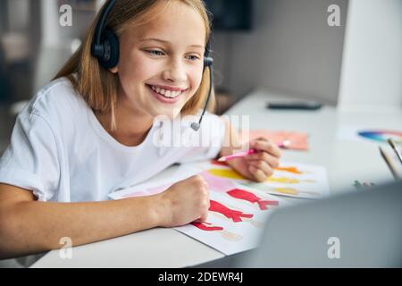 Kind in Kopfhörer vor ihr schauen Stockfoto