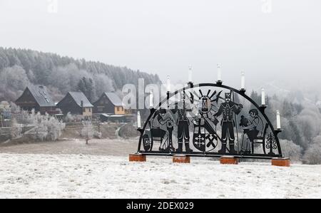 Oberwiesenthal, Deutschland. Dezember 2020. Ein Schwibbogen steht allein auf einer verschneiten Wiese. In keinem anderen Bundesland breitet sich die Coronapandemie derzeit so schnell aus wie in Sachsen. Daher sind jetzt strengere Maßnahmen in Kraft, einschließlich Ausstiegsbeschränkungen. Quelle: Jan Woitas/dpa-Zentralbild/dpa/Alamy Live News Stockfoto