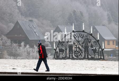 Oberwiesenthal, Deutschland. Dezember 2020. Ein Mann geht an einem schwibbogen vorbei. In keinem anderen Bundesland breitet sich die Coronapandemie derzeit so schnell aus wie in Sachsen. Daher sind jetzt strengere Maßnahmen in Kraft, einschließlich Ausstiegsbeschränkungen. Quelle: Jan Woitas/dpa-Zentralbild/dpa/Alamy Live News Stockfoto