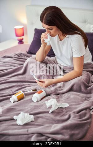 Die besorgte Frau lernt über ihre Temperatur Stockfoto