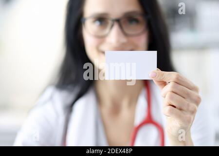 Lächelnder Arzt Porträt hält weiße Visitenkarte in der Hand Stockfoto