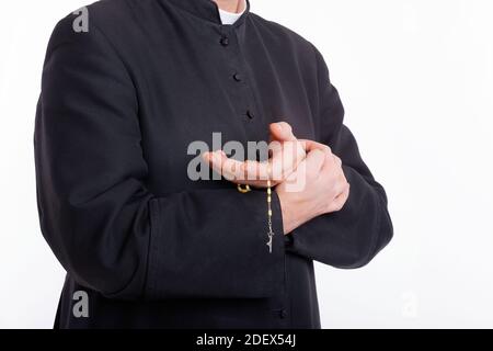 Die Hände des katholischen Priesters halten den Rosenkranz Stockfoto