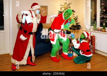 Der Weihaftertsmann fängt den Grinch und Mrs. Grinch stiehlt Geschenke und fordert sie auf, eine Schutzmaske zu tragen. GEEK ART - Bodypainting und Transforming: 'Der Grinch stiehlt Weihafteren' Fotoshooting mit Enrico Lein als Grinch, Maria Skupin als Frau Grinch und Fabian Zesiger als Weihaftertmann in der Villa Czarnecki. Hamelin, 30. November 2020 - EIN Projekt der Fotografin Tschiponnique Skupin und des Körpermalers und Transformers Enrico Lein Stockfoto