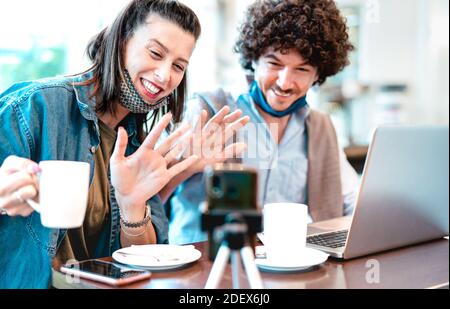 Junge Millennialpaare teilen kreative Inhalte mit Facemask - Digital Marketingkonzept mit Influencer der nächsten Generation, die Spaß am Video haben Streamen Stockfoto