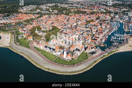 Historisches Fischerdorf Urk in Flevoland, Niederlande, mit einem Leuchtturm und einem Hafen, beliebtes Touristenziel. Luftaufnahme. Stockfoto