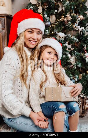 Porträt der glücklichen Familie mit Geschenken auf dem Boden zu Hause In der Nähe von Weihnachtsbaum Stockfoto