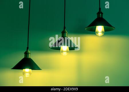 Drei Lampen mit klassischen Glühlampen in grünem Licht Stockfoto