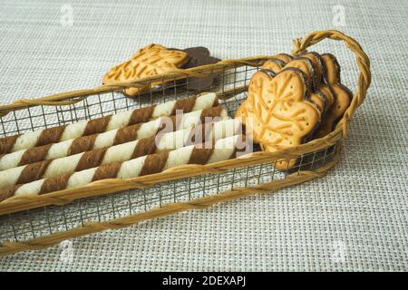 Röhren mit Sahne und Kuchen im Korb, Nahaufnahme Stockfoto