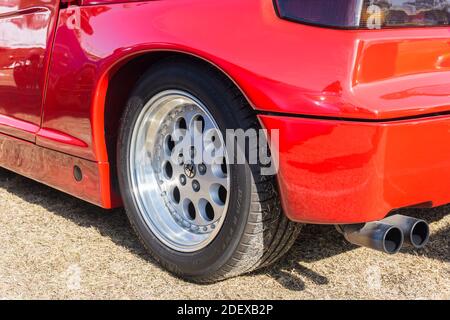 Nahaufnahme des linken Leichtmetallrads hinten, des Radkastenrads und der Auspuffanlagen eines roten Alfa Romeo SZ Sportcoupés draußen bei Sonnenschein Stockfoto