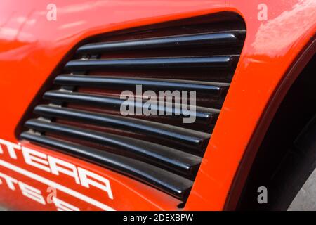 Nahaufnahme der Lüftungsschlitze auf der Seite eines roten De Tomaso Pantera GT5-S draußen bei Sonnenschein. Stockfoto